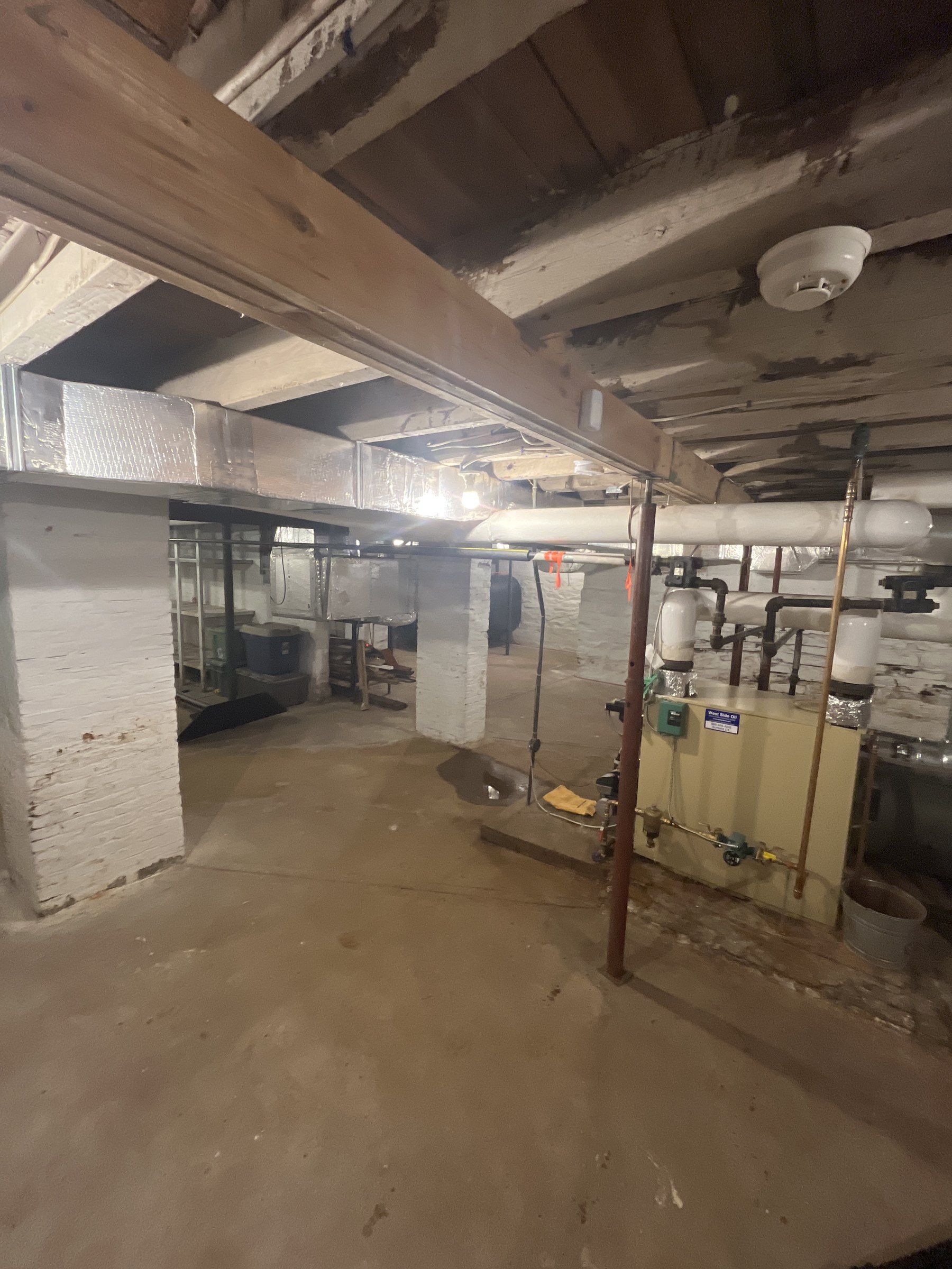 Basement of a 1790s timber-frame house in Suffield with a modern beam line added under the first-floor joists on temporary steel posts