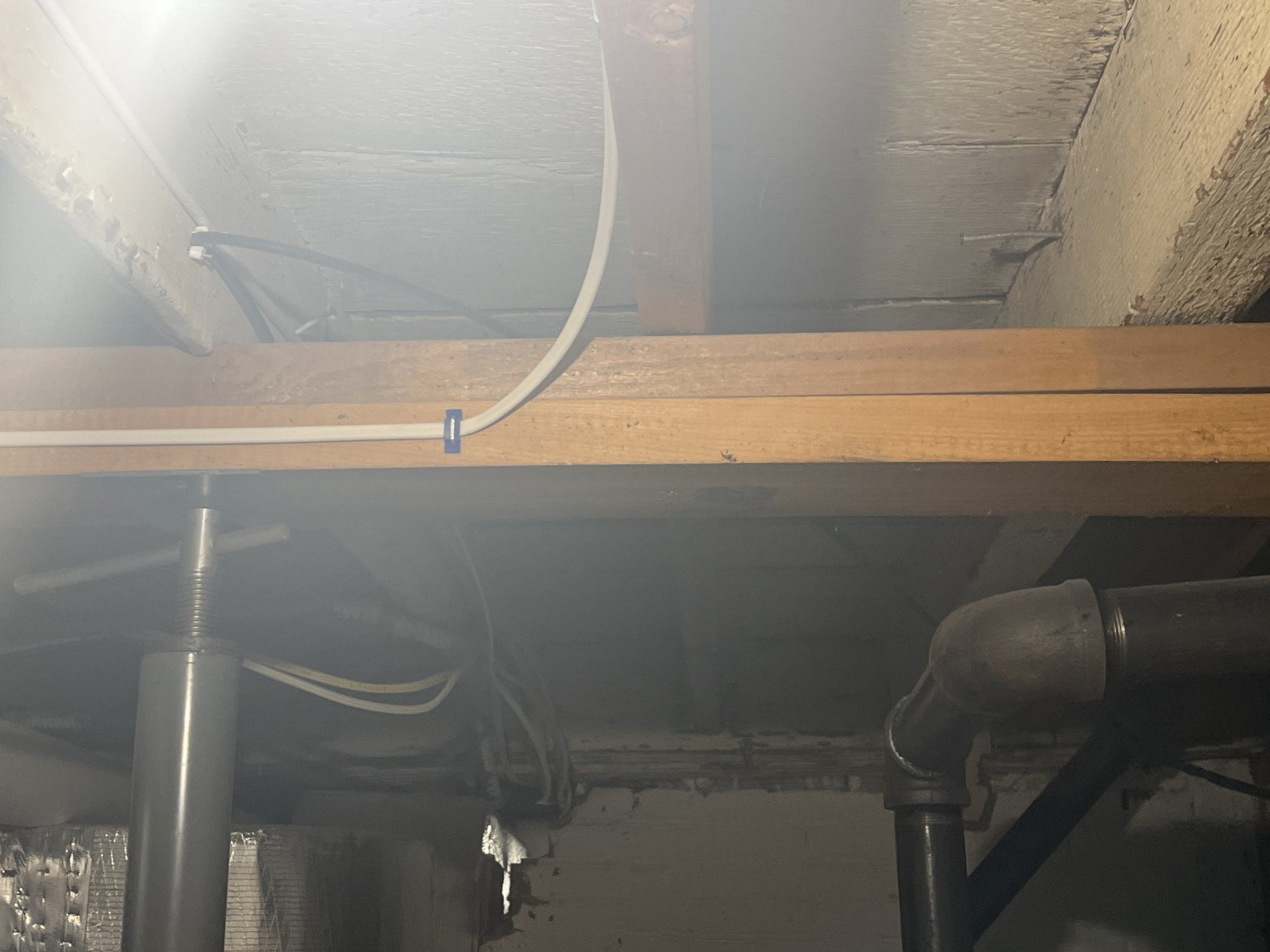 Two 2x4s laid flat on top of each other under floor joists, dropped in as a beam on temporary posts