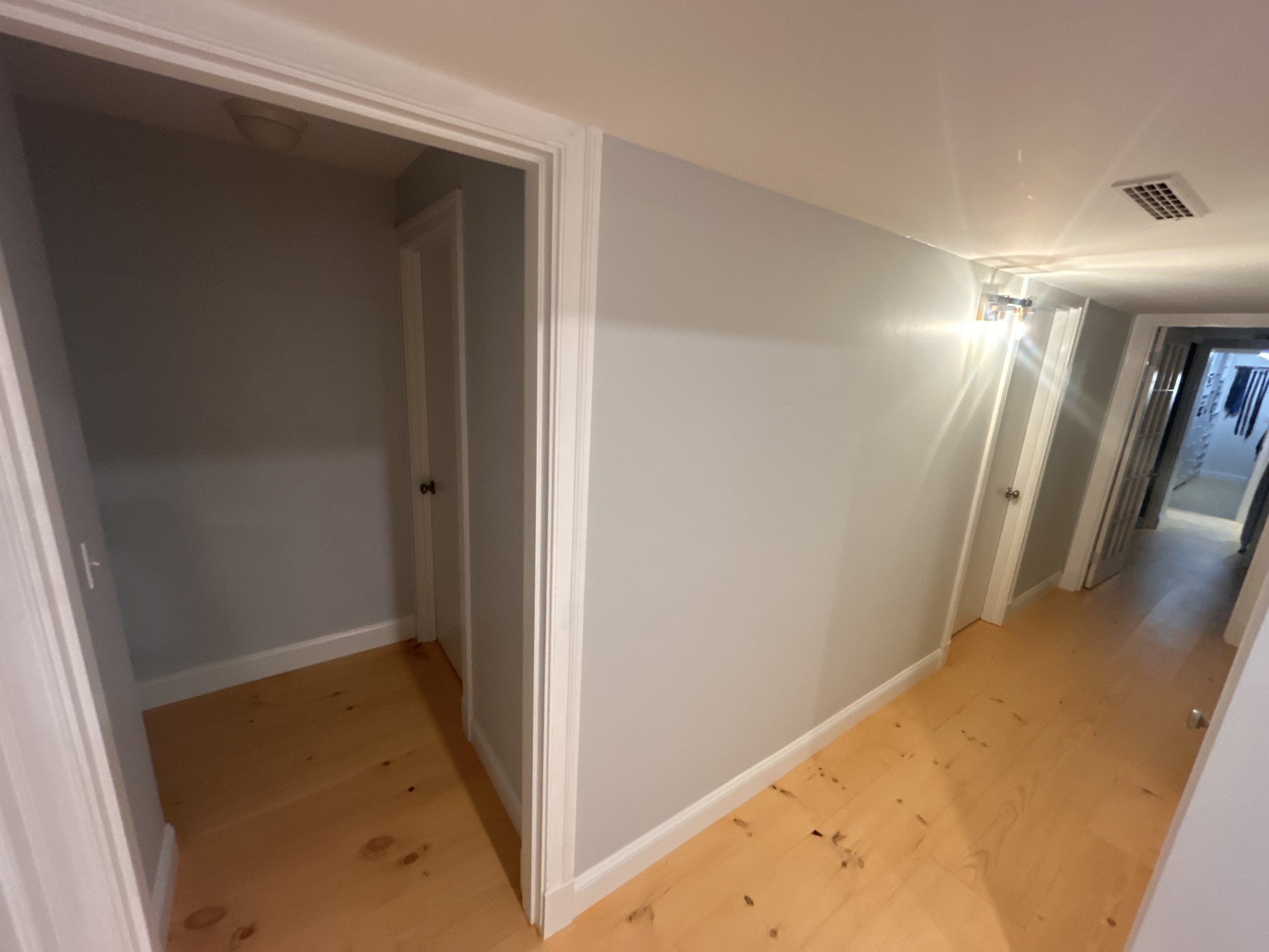 Boxed beam line running through a finished basement hallway over cased door openings