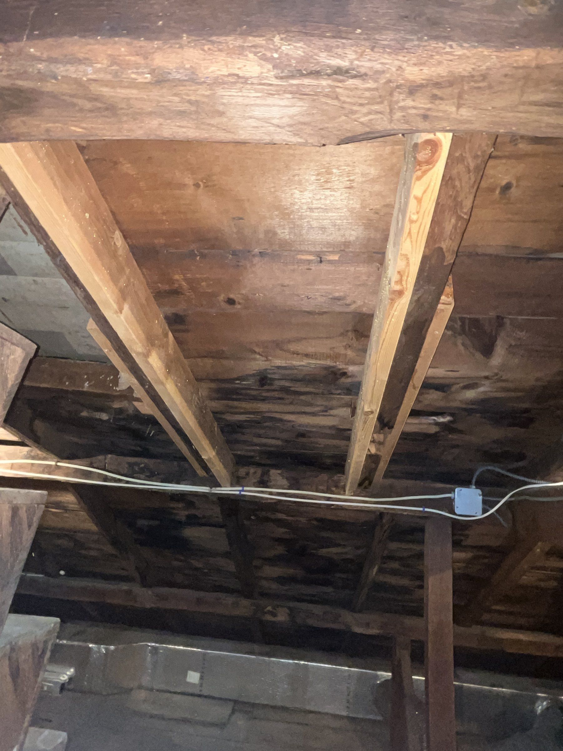 Attic of a 1790s house showing new lumber sistered beside original hewn rafters that had been cut through